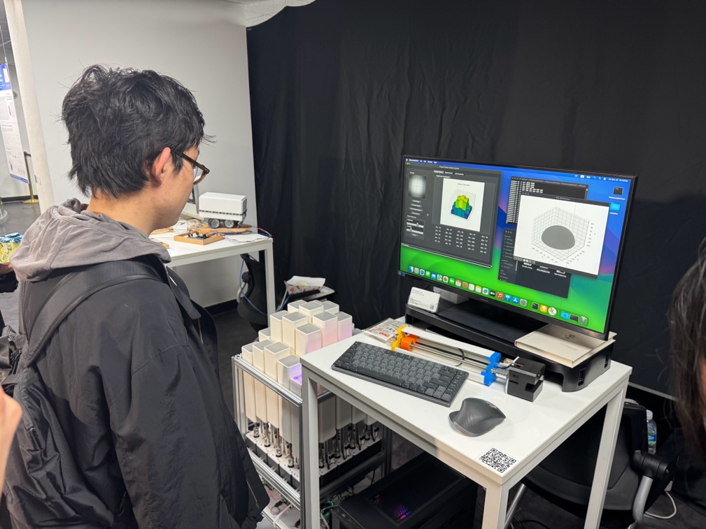 Visitor using the image-to-heightmap interface beside the kinetic surface