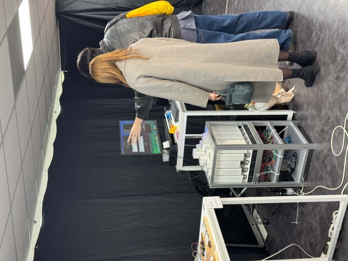 Visitors viewing the LLM-assisted kinetic surface demonstration